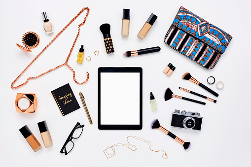 Flat lay of digital tablet surrounded by beauty products
