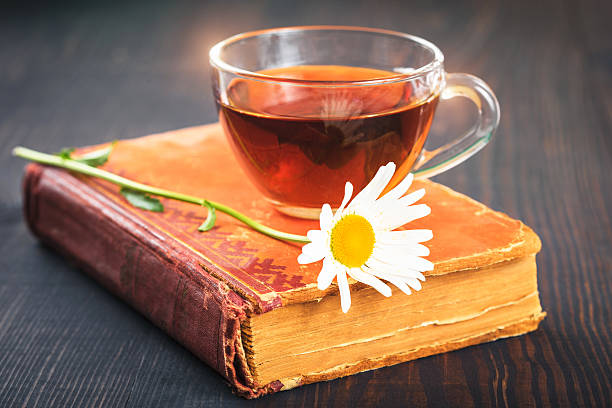 istock Cup of tea, chamomile and a book on the table 614838094