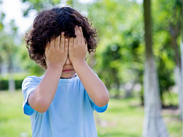 公園で目を覆う小さなアジアの少年 - shy child little boys hiding ストックフォトと画像