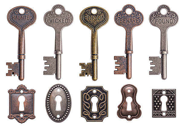 ключи и замочные скважины - isolated brass key macro стоковые фото и изображения