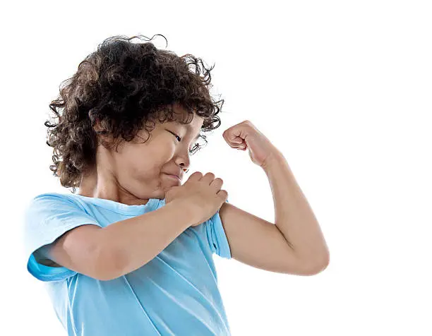 Photo of Little boy showing his muscles