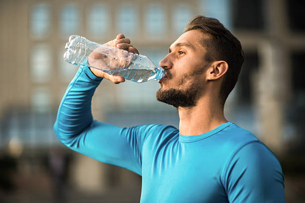istock Athletic man drinking fresh water from the bottle. 614841222