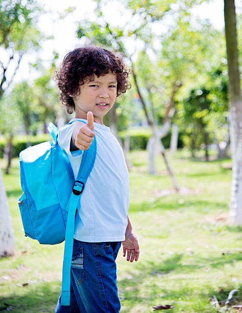 jeune garçon avec sac à dos - hand sign human hand ok sign grass photos et images de collection