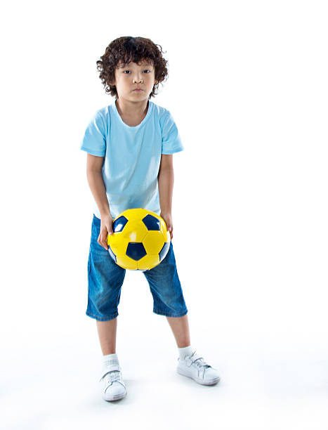 istock Little boy playing football 614843176