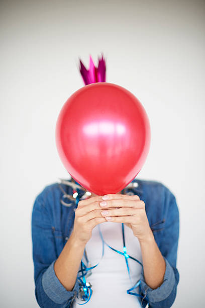 istock Woman hiding behind a red balloon 614843884
