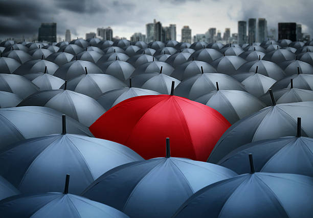istock red umbrella outstanding from the others, uniqueness 614845262