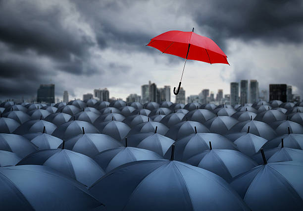 istock red umbrella outstanding from the others, uniqueness 614845276