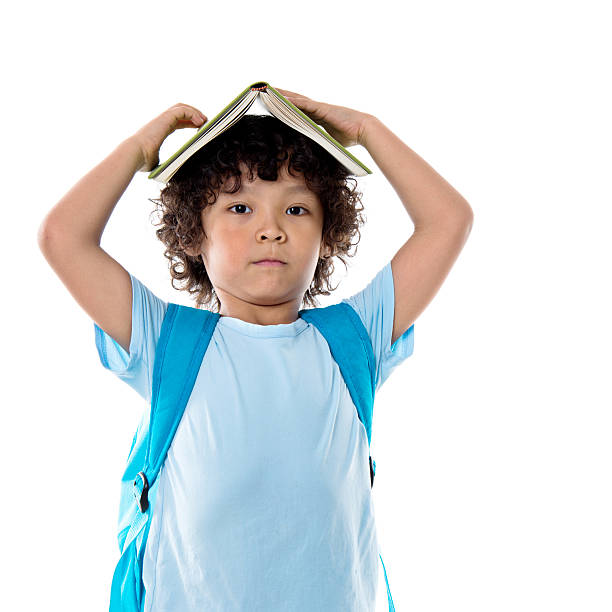 istock Little asian boy with a book against white background 614845946