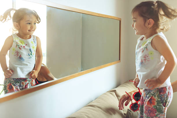 istock Baby girl sofa jumping at mirror 614845992