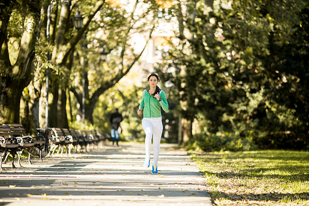 istock Young woman running in the park 614846010