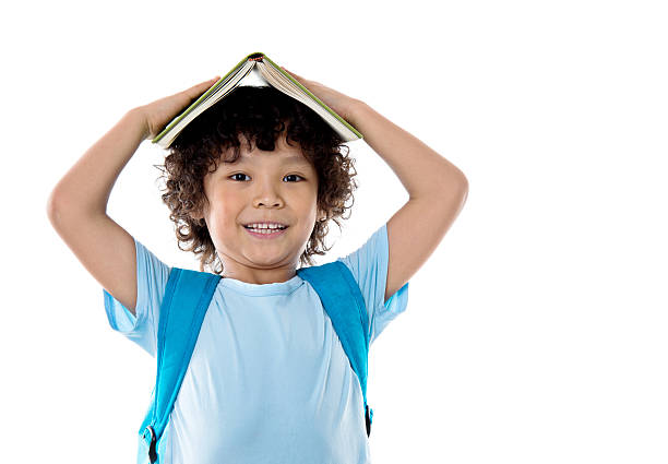 little asian boy with a book against white background - little boys preschooler back to school backpack imagens e fotografias de stock
