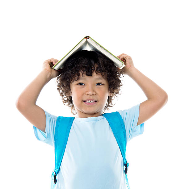 istock Little asian boy with a book against white background 614846124
