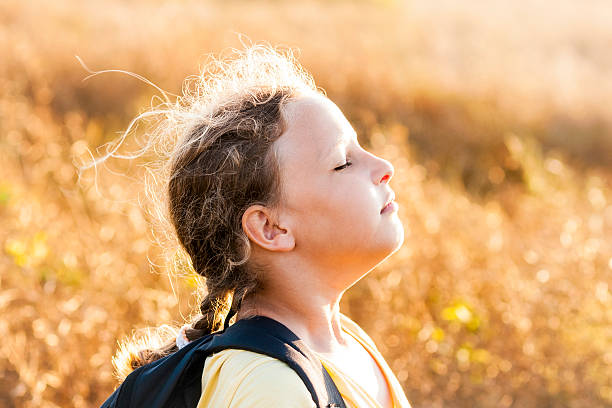 Girl Smells Fresh Air Summer girl with rucksack on sunset meadow smelling fresh air. scene scented stock pictures, royalty-free photos & images