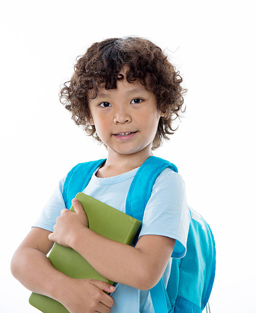 little asian boy with a book against white background - little boys preschooler back to school backpack imagens e fotografias de stock