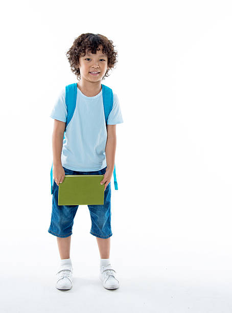 白い背景に対する本を持つ小さなアジアの少年 - little boys preschooler back to school backpack ストックフォトと画像