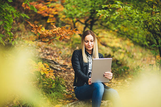 istock girl using tablet in the nature 614848248