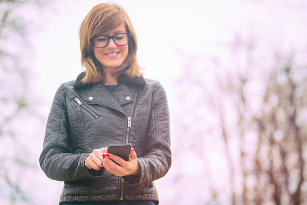 istock Girl using cellphone outdoors. 614848652