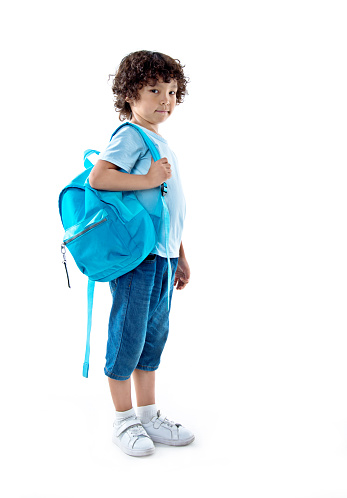Cute little girl on her first day going to school. Healthy beautiful child walking to nursery preschool and kindergarten. Happy child with eyeglasses with backpack on the city street, outdoors