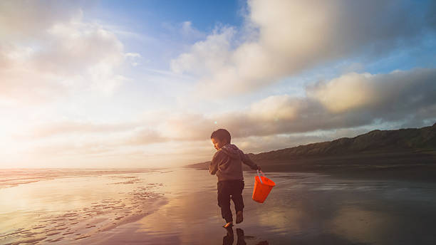 dziecko korzystających na plaży. - murawai beach zdjęcia i obrazy z banku zdjęć