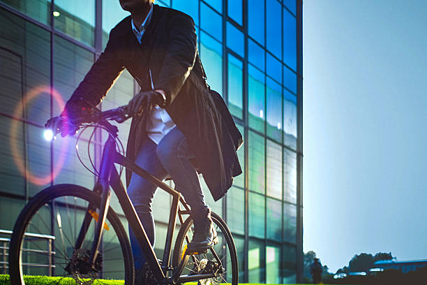 istock Handsome man riding bicycle beside the modern office building 614851114
