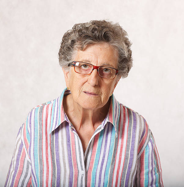 светоотражающая старшая женщина. серый фон - respect women human teeth people стоковые фото и изображения