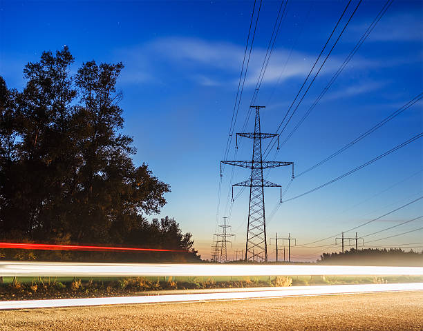 istock Electricity transmission power lines at sunset High voltage tower. 614853882