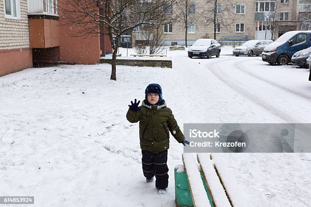 Boy Playing On A Snowy Street Stock Photo - Download Image Now - Car, Playful, Playing