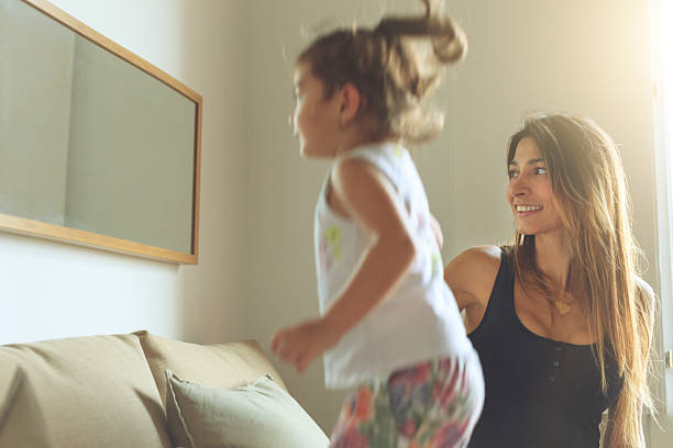 istock Baby girl sofa jumping at mirror 614854292