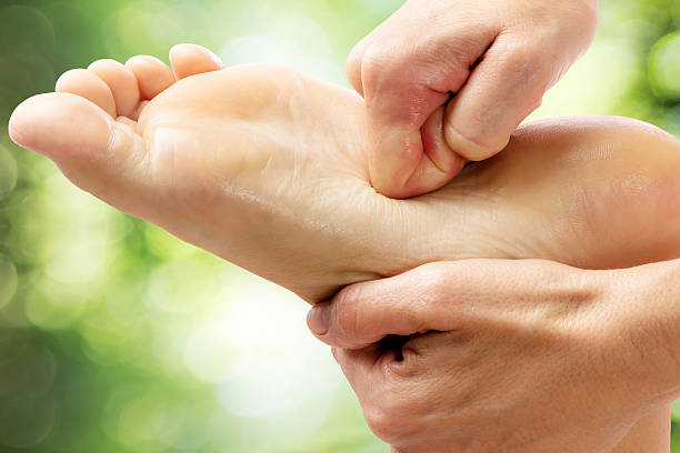 istock Healing foot massage against green background. 614855606