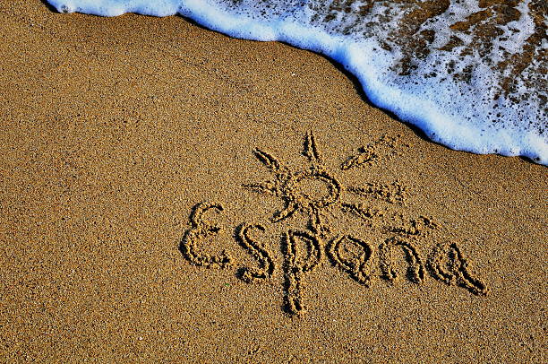 istock Spain sign on the sand beach 614856944