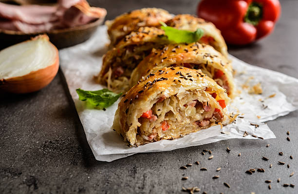 Savory strudel with sour cabbage, bacon and onion Savory strudel stuffed with sour cabbage, bacon, red pepper and onion strudel stock pictures, royalty-free photos & images