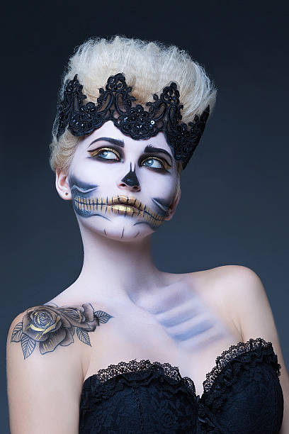 istock beautiful woman with make-up skeleton half 614857324