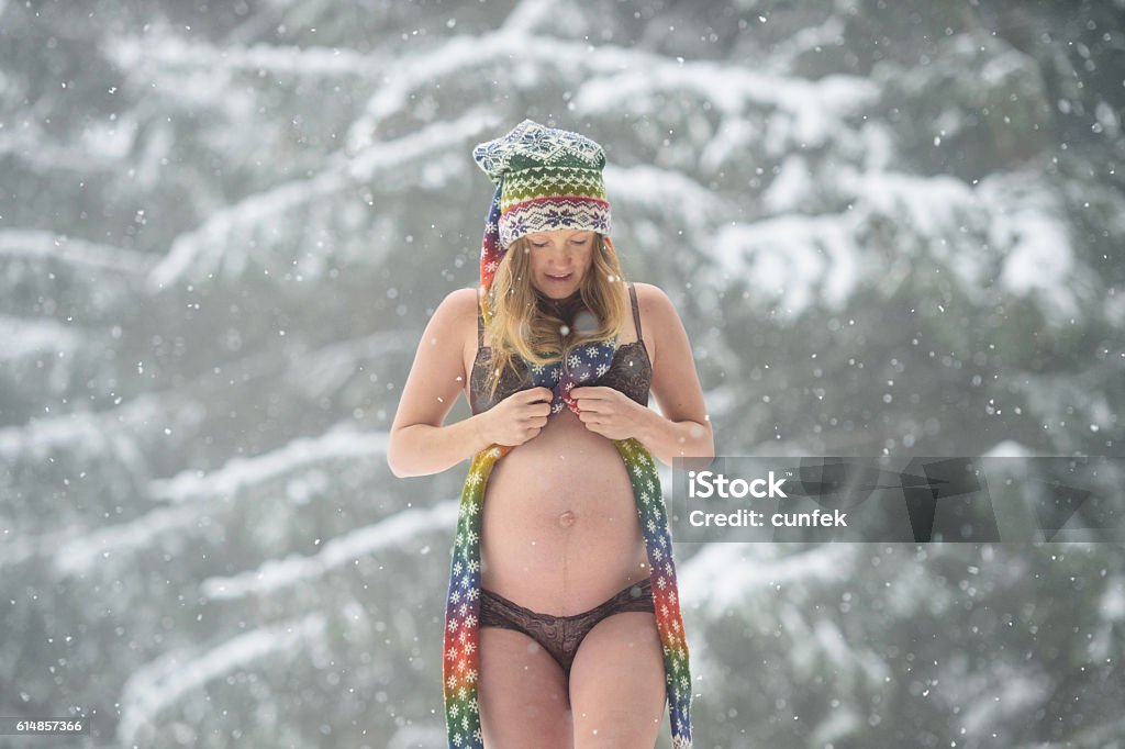 Beautiful Maternity Portrait In Winter Young mom to be, pregnant and posing in snowy landscape Tree Stock Photo