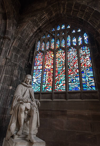 Manchester, England - September 23, 2016: Statue of Humphrey Chetham and colorful stained glass window inside the famous  Manchester Cathedral.