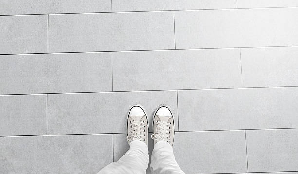 persona que toma la foto de sus pies de pie en el suelo en blanco - one floor fotografías e imágenes de stock