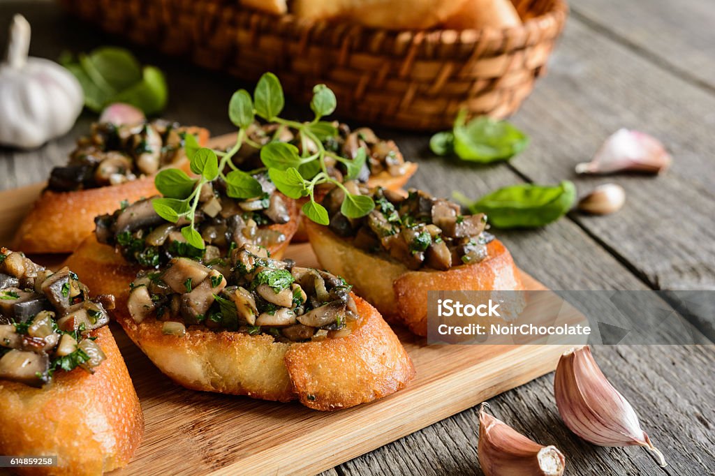 Fried baguette with mushrooms, garlic and herbs Fried baguette slices with mushrooms, garlic and herbs Edible Mushroom Stock Photo