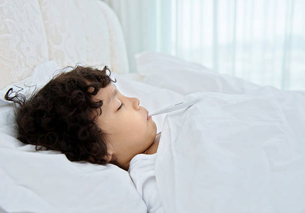 istock Little boy with thermometer in bed 614859648