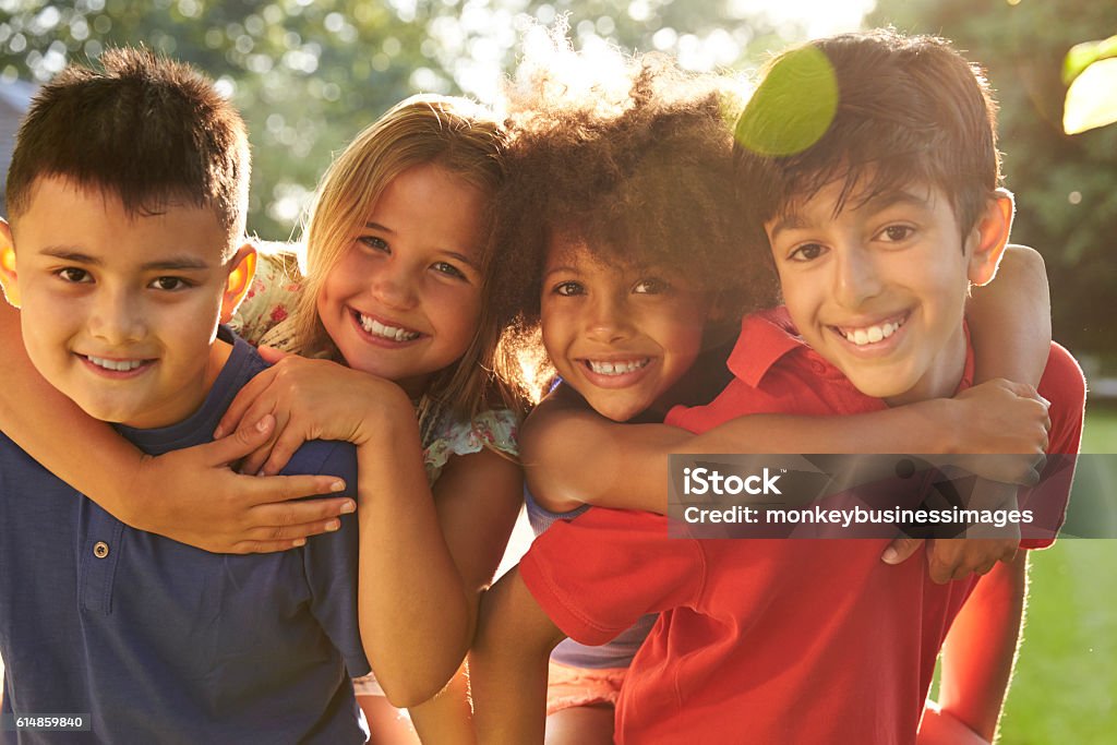 Portrait Of Four Children Having Fun Outdoors Together Child Stock Photo