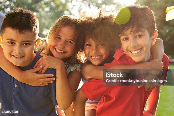 Portrait Of Four Children Having Fun Outdoors Together Stock Photo - Download Image Now