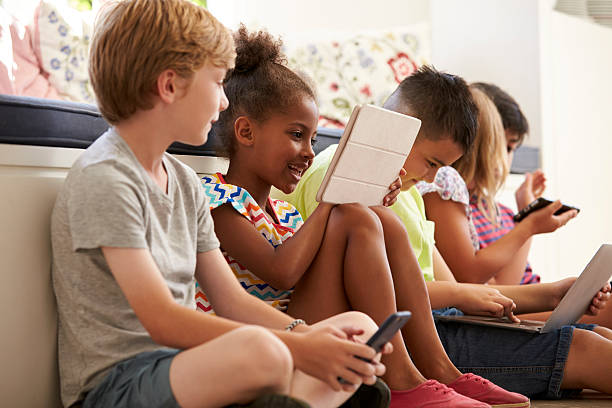 istock Group Of Children Sit On Floor And Use Technology 614860048