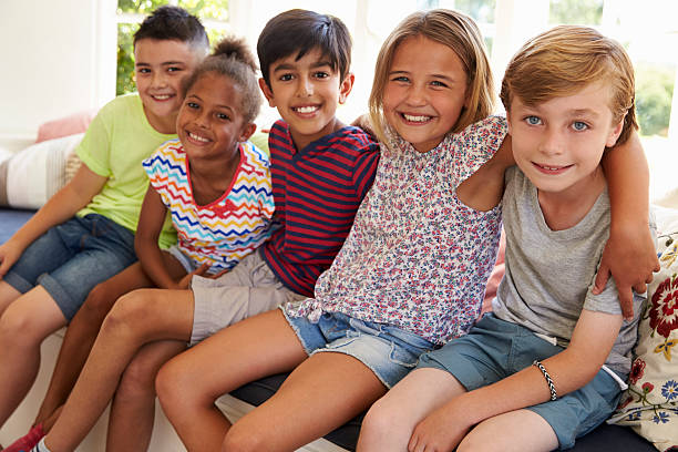 istock Group Of Multi-Cultural Children On Window Seat Together 614860114