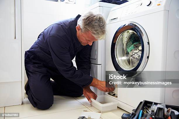 Plumber Fixing Domestic Washing Machine Stock Photo - Download Image Now - Repairing, Washing Machine, Appliance