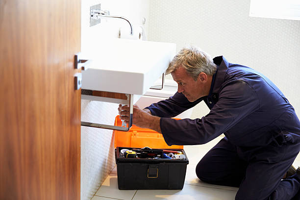 istock Plumber Working On Sink In Bathroom 614860250