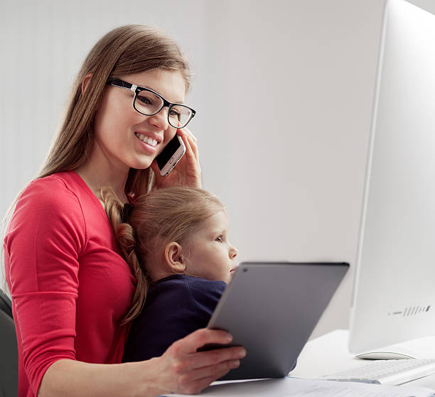 istock Busy woman with child in office 614860300