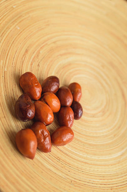 Delicious Ziziphus jujuba on a wooden plate, commonly called jujube or jujuba, red date, Chinese date, Korean date, or Indian date is a species of Ziziphus in the buckthorn family (Rhamnaceae). It is used primarily as a shade tree that also bears fruit.