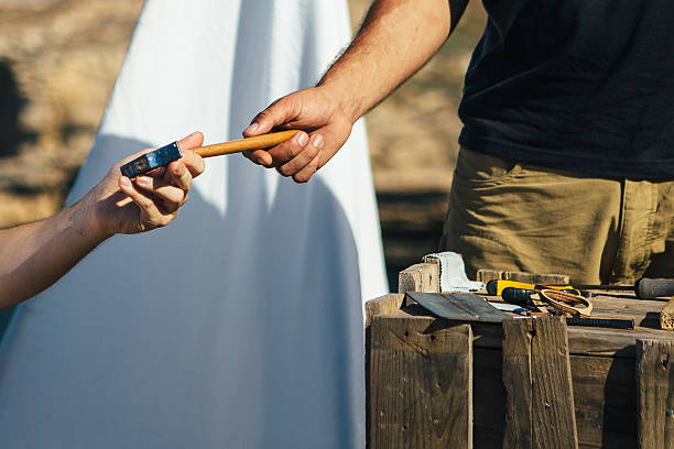 Master takes hammer form hands of another man Close up of on unrecognizable man gives a hummer to another man borrowing stock pictures, royalty-free photos & images