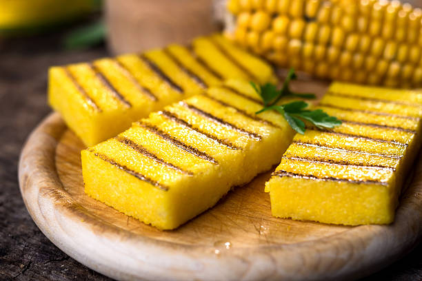 grillowana polenta na starym drewnianym tle - polenta zdjęcia i obrazy z banku zdjęć