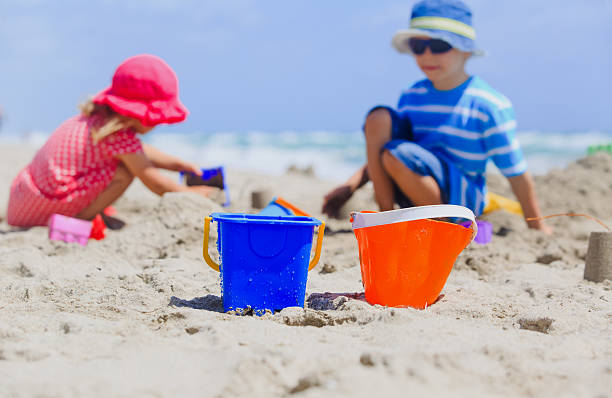 istock kids play with sand on beach 614862238