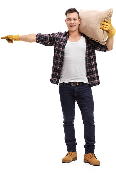istock Male farmer holding a burlap sack and pointing 614862296
