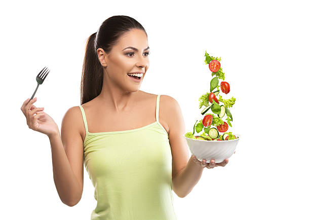 Beautiful, fit young woman holding a bowl of salad stock photo